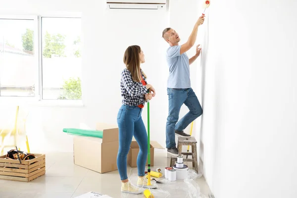 Feliz jovem casal fazendo reparação em sua nova casa — Fotografia de Stock