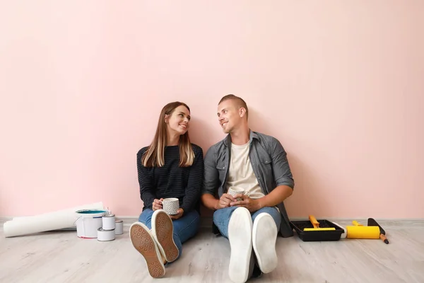 Feliz joven pareja descansando durante la reparación en su nueva casa — Foto de Stock