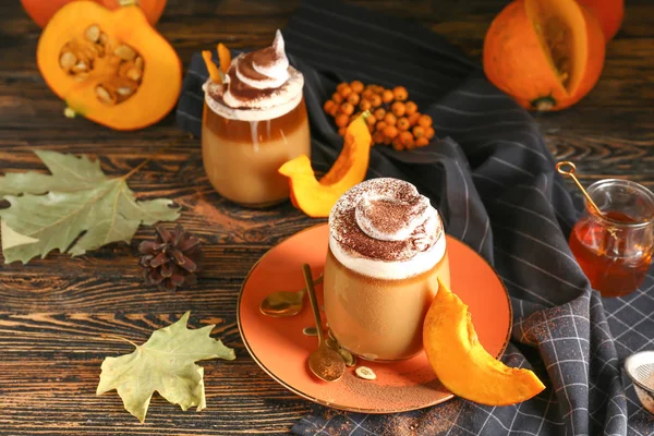 Glass of tasty pumpkin coffee on table