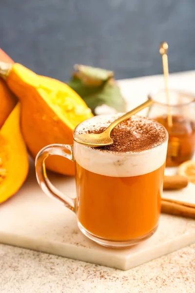 Cup of tasty pumpkin coffee on table