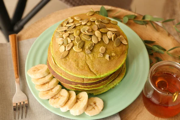 Plate med velsmakende grønne pannekaker og honning på bordet – stockfoto