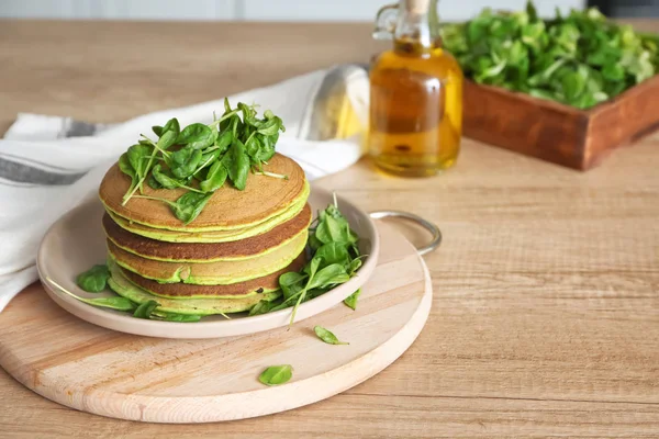 Plate with tasty green pancakes on table — Stock Photo, Image