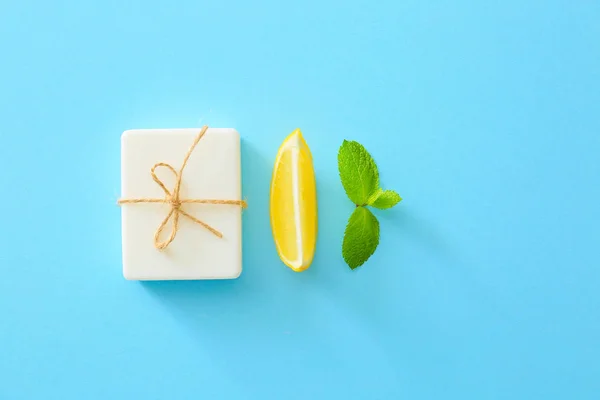 Soap, lemon and mint on color background — Stock Photo, Image