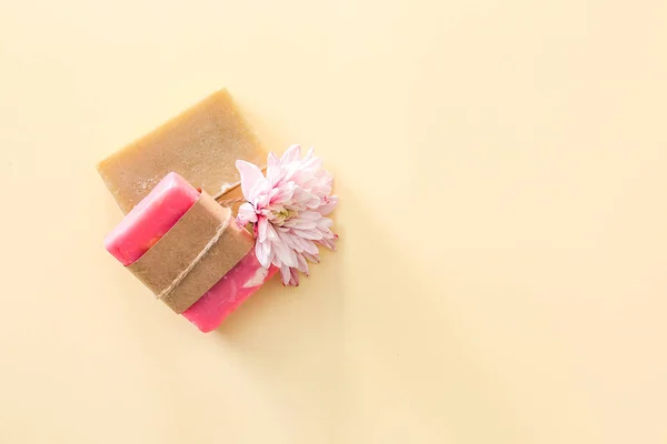 Soap bars and flower on color background — Stock Photo, Image