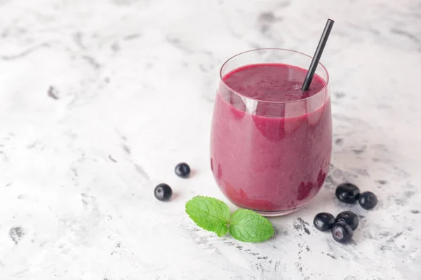 Glass of acai smoothie on light table — Stock Photo, Image