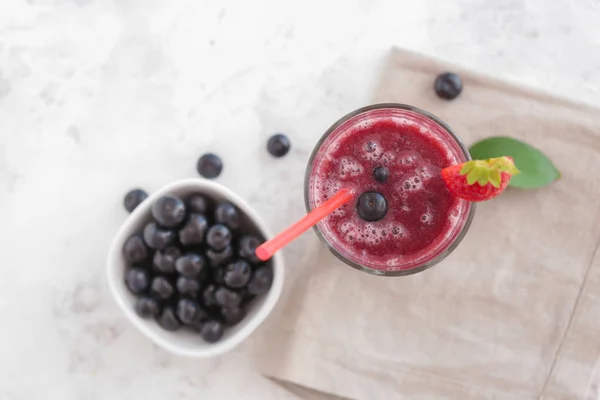 Glass of acai smoothie on light table — Stock Photo, Image