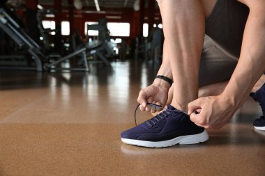 Spor salonunda ayakkabı bağcıkları bağlama sportif genç adam