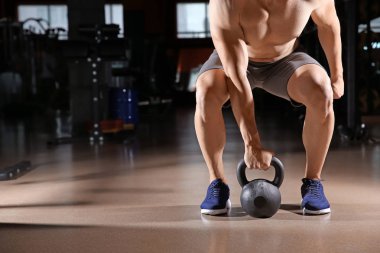 Spor salonunda Kettlebell ile sportif genç adam eğitimi