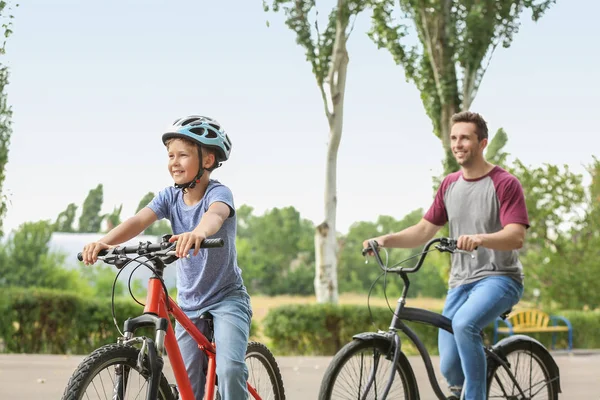 Feliz padre e hijo montando bicicletas al aire libre —  Fotos de Stock