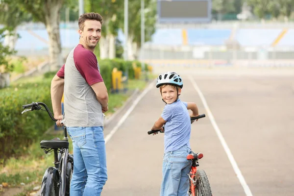 Feliz padre e hijo montando bicicletas al aire libre —  Fotos de Stock