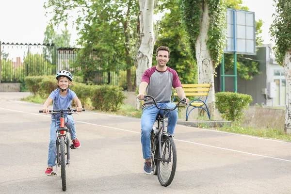 Šťastný otec a syn jízdní kola venku — Stock fotografie