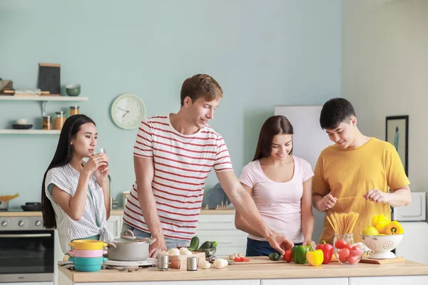 Glückliche Freunde kochen gemeinsam in der Küche — Stockfoto