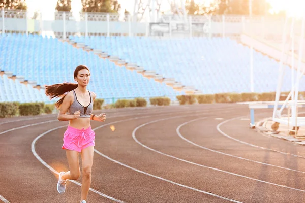 Sporty Asian woman running at the stadium — Stock Photo, Image