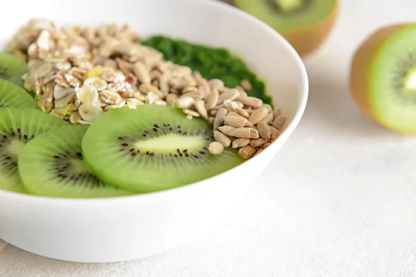 Cuenco con sabrosos copos de avena y kiwi en la mesa blanca, primer plano — Foto de Stock