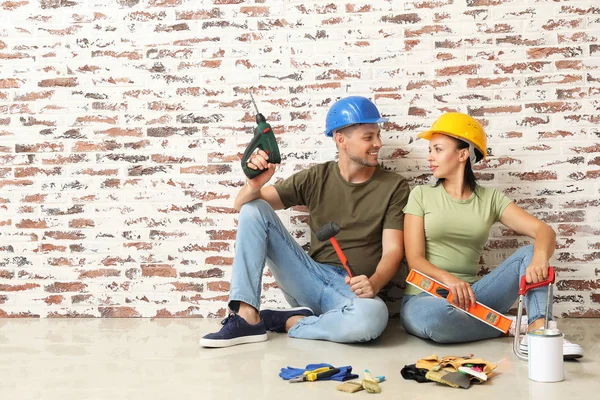 Pareja feliz con suministros durante la reparación en su nueva casa — Foto de Stock