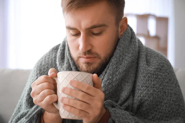 自宅で熱いお茶を飲む病気の男 — ストック写真