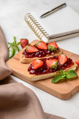 Beyaz masada kızarmış ekmek ve çilek reçeli ile ahşap tahta