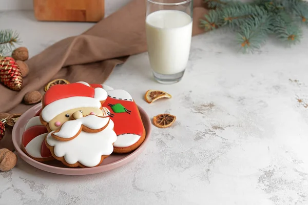 Placa con sabrosas galletas de Navidad y vaso de leche en la mesa — Foto de Stock