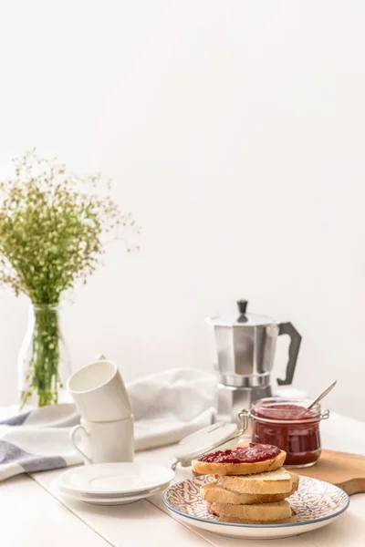 Placa con pan tostado y mermelada dulce sobre mesa blanca — Foto de Stock