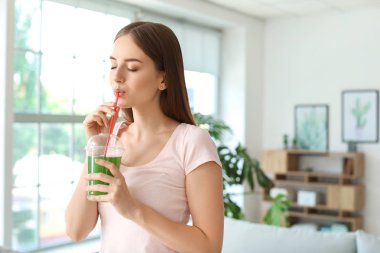 Genç kadın evde sağlıklı sebze suyu içme
