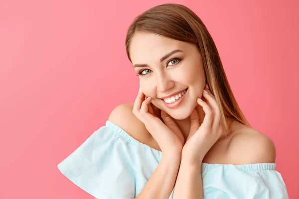 Mooie jonge vrouw op kleur achtergrond — Stockfoto