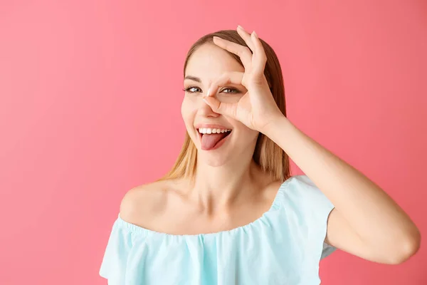 Mujer joven divertida sobre fondo de color — Foto de Stock