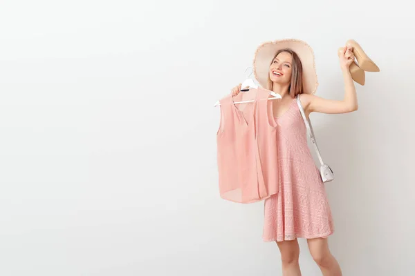 Jeune femme avec des vêtements élégants et accessoires sur fond blanc — Photo