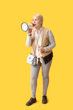 Arka planda megafonla bağıran olgun bir kadın.