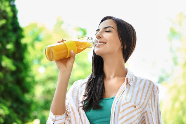 Young woman drinking healthy juice outdoors — Stock Photo, Image