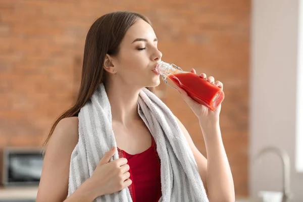 Young sporty woman drinking healthy vegetable juice in kitchen — Stock Photo, Image