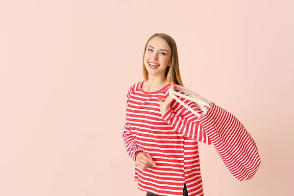 Beautiful young woman with bag on color background — Stock Photo, Image