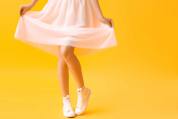 Jeune femme élégante en chaussures et jupe sur fond de couleur — Photo