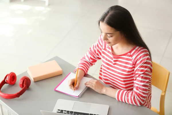Young female student preparing for exam in classroom — Stock Photo, Image
