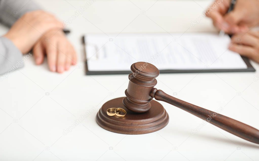 Judge gavel and rings on table in lawyer's office. Concept of divorce