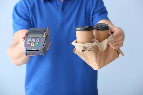 Worker of food delivery service with payment terminal on color background, closeup — Stock Photo, Image