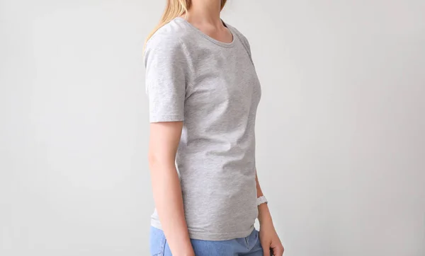 Donna in elegante t-shirt su sfondo chiaro — Foto Stock
