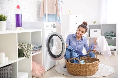 Güzel genç bayan evde çamaşır yıkıyor.