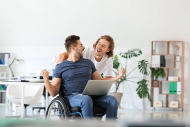 Ofiste meslektaşı ile mutlu engelli genç adam