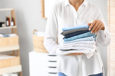 Evinde bir yığın temiz havlusu olan güzel genç bir kadın.