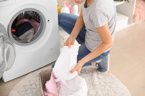 Bela jovem mulher fazendo lavanderia em casa — Fotografia de Stock