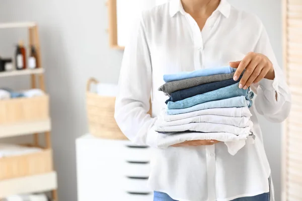 Mulher bonita com pilha de toalhas limpas em casa — Fotografia de Stock