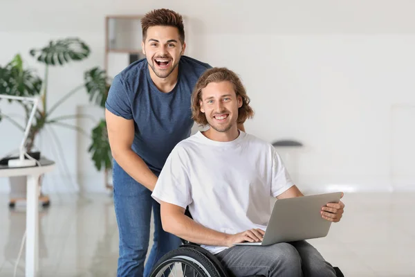 Joven discapacitado feliz con colega en el cargo —  Fotos de Stock