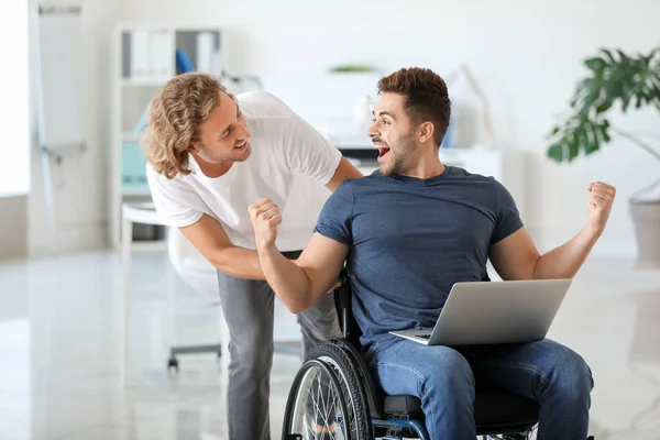 Ευτυχισμένος ανάπηρος νεαρός άντρας με συνάδελφο στο γραφείο — Φωτογραφία Αρχείου