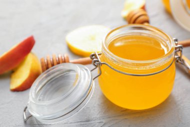 Gri arka plan üzerinde tatlı bal, elma ve limon Kavanoz
