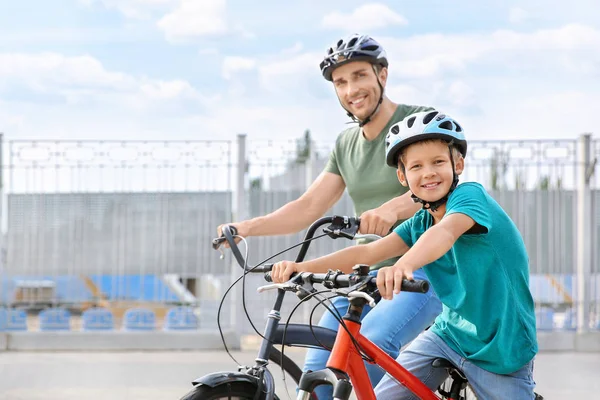 Feliz padre e hijo montando bicicletas al aire libre —  Fotos de Stock