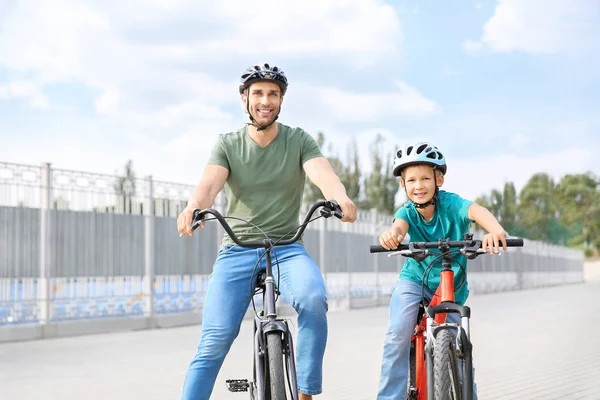 Щасливий батько і син катаються на велосипедах на відкритому повітрі — стокове фото