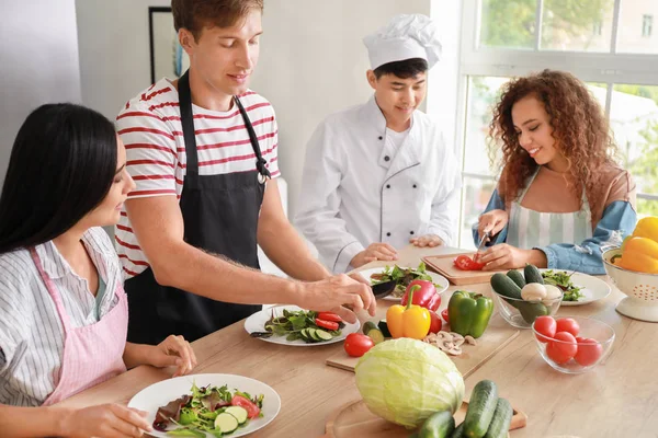 Asiatischer Koch und eine Gruppe junger Leute während eines Kochkurses — Stockfoto