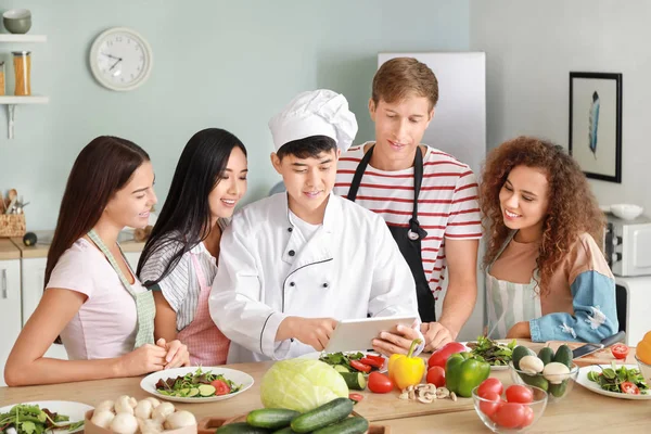 Азиатский шеф-повар и группа молодых людей во время кулинарных занятий — стоковое фото