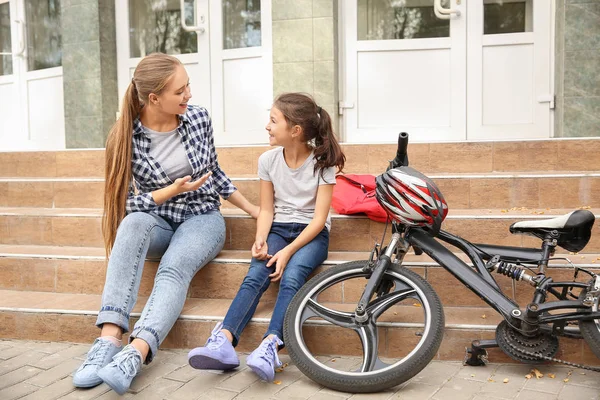 Žena a její dcerka s bicykly, sedící na schodech venku — Stock fotografie