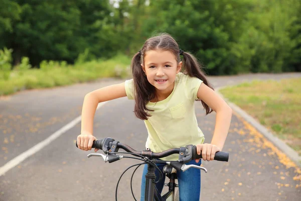 Little girl riding bicycle outdoors — Stock Photo, Image